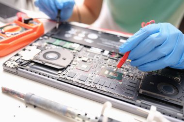 Technician measures the voltage on motherboard of computer electronic digital multimeter. PC diagnostics with multimeter concept