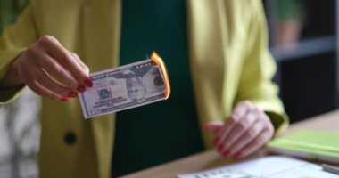 Business woman and burning 50 dollar bill at workplace. Economy collapse and inflation concept