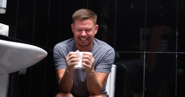 Emotional Unhappy Man Suffering Diarrhea Holding Roll Toilet Paper Sitting — Vídeos de Stock