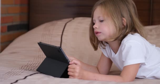 Little Girl Lies Bed Uses Tablet Home Kids App Learning — Vídeo de Stock