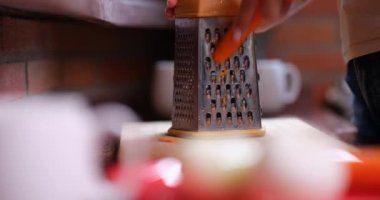 Fresh sliced carrots on grater and hands closeup. Benefits of shredded carrots concept