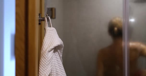 Γυμνή Γυναίκα Πλένεται Στο Ντους Λευκό Μπουρνούζι Κρέμεται Στο Γάντζο — Αρχείο Βίντεο