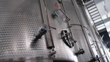 Modern wine distillery and brewery with brew kettles pipes and stainless steel tanks. Production equipment of chemical and pharmaceutical industries