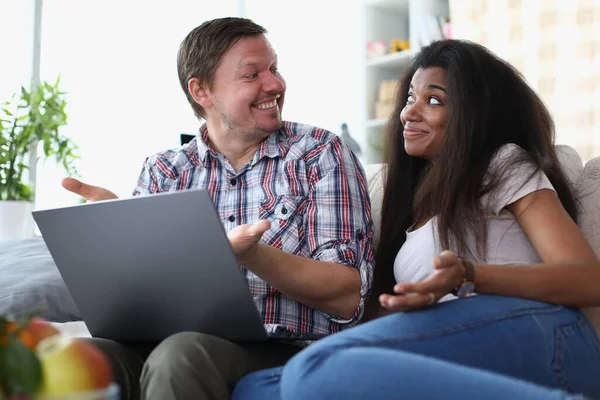 Interethnic Family Couple Laughing Chatting While Sitting Sofa Home Laptop — Stockfoto