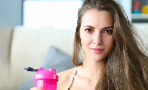 Portrait of beautiful strong happy young athletic woman with bottle of drinking water. Beauty health youth and sport