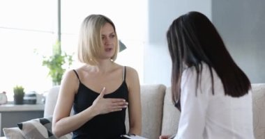 Young woman sitting on the couch talking to the doctor, close-up. Symptoms of the disease, patient card, ambulance