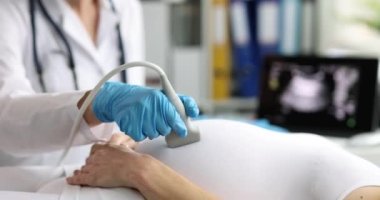 Doctor in the process of ultrasound of the abdomen of a pregnant woman, close-up. Fetal diagnosis