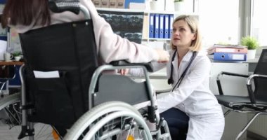 A neurologist beats a man in a wheelchair with a hammer on the knees, close-up. Checking reflexes after injury