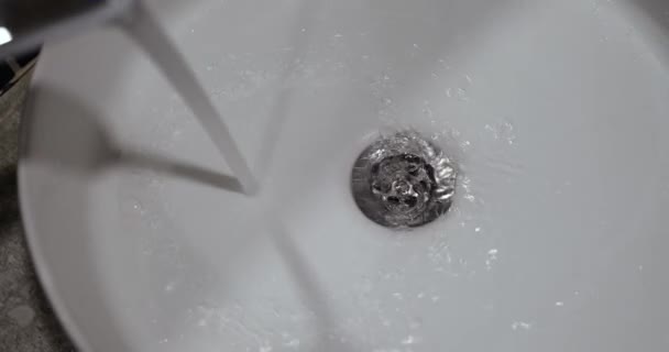Ένα Ρυάκι Νερού Ρέει Από Μια Βρύση Ένα Λευκό Νεροχύτη — Αρχείο Βίντεο