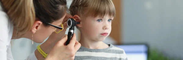 女性小児科医は 診療所で内視鏡を使って少女の耳を見ています 子供の難聴の診断の概念 — ストック写真
