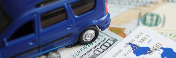 蓝色玩具车站在美元钞票和塑料信用卡特写 购买汽车的概念 — 图库照片