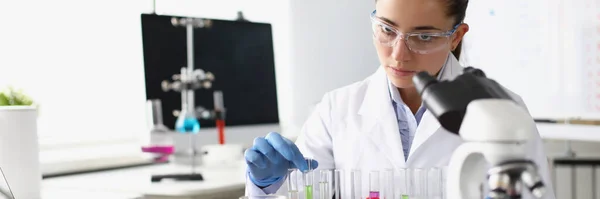 Хімічна Жінка Тримає Пробірку Рідиною Перед Мікроскопом Лабораторії Концепція Фармацевтичної — стокове фото