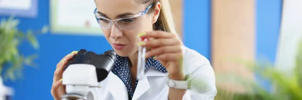 Mujer Científica Química Mirando Través Del Microscopio Sosteniendo Tubo Ensayo —  Fotos de Stock