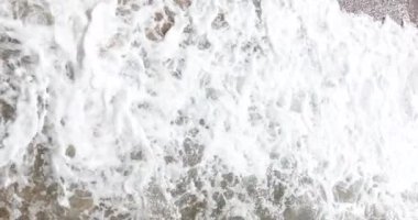 Walking on sea strong waves with foam top view. Sunny day on tropical coast and wildlife seascape