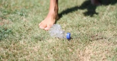 Man removes plastic bottle from grass. Plastic pollution of nature and ecology