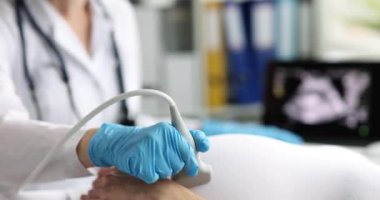 Pregnant woman visits female doctor in maternity hospital and does medical ultrasound. Worries about health of child and concept of healthy motherhood