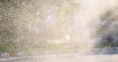 Lawn sprinkler sprays water on green grass. Irrigation technique in garden and water splashes background