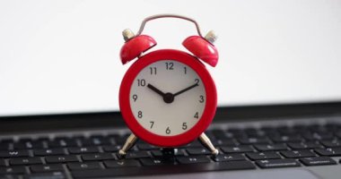 Red alarm clock for ten on laptop keyboard for business term. Timetables urgency scheduling remote work freelancing