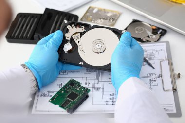 Technician repairs computer hard drive from motherboard. Hard drive diagnostic services concept