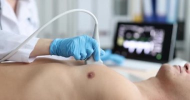 A young man on an ultrasound of the chest, close-up, slowmotion. Health check, ultrasound scan of organs