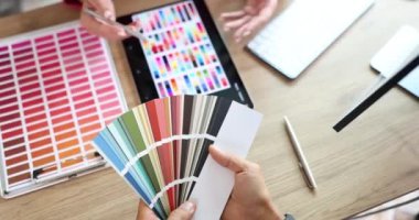 İç mekan için renk seçimi ve tartışma sırasında tasarımcıların ellerinin genel görünümü. Tasarımcı müşterilerle iletişim kurar ve renk paletinde renk ve tonları seçer