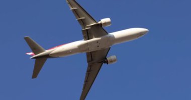 Beyaz jet uçağı mavi gökyüzüne doğru havalanıyor. Seyahat turizmi ve uçak biletleri