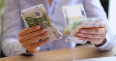 Avro banknotlarını tutan ve sayan kadınların yakınlaşması. Kadınların elinde farklı değerlerde nakit para.