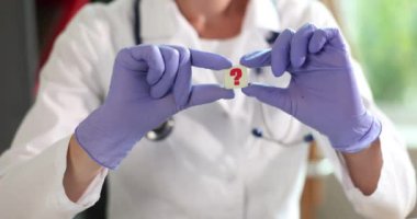 Doktor soru ikonunu tutuyor. Sık sık tıpla ilgili sorular sorardı. Klinikte sorular ve cevaplar