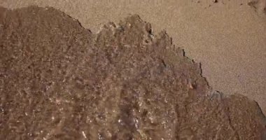 Kuma çizilmiş hüzünlü ifadeler deniz dalgalarıyla sürükleniyor. Kötü ruh hali depresyon stres ve tedavi denizi