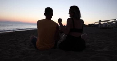 Aşık bir adam ve bir kadın plajda sarılıyorlar. Çocuk koşup onlara sarılıyor. Aile tatili aşk ve seyahat