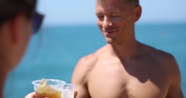 朋友或夫妻在夏天的海滩上喝啤酒和碰杯 夏天热和软饮料中的友好沟通 — 图库视频影像