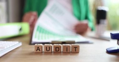 Evrak işleriyle uğraşan kadın yönetici mali belgelerin denetimini yürütüyor. Uzman, istatistiksel bilgi kullanarak araştırma yürütüyor.