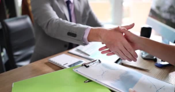Два Бизнесмена Пожимают Друг Другу Руки Сидя Столом Диаграммами Финансовых — стоковое видео