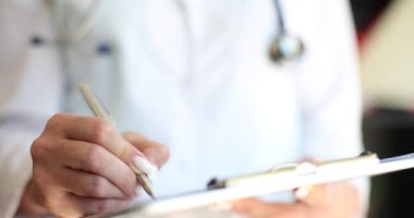 Terapist doktor elleri kalemle tıbbi yazı yazar. Sağlık sözleşmesi ve sigorta