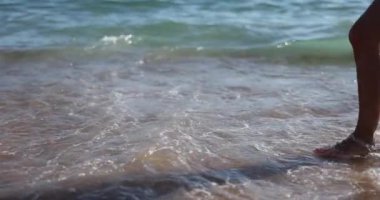 Bir çift deniz kıyısında birbirleriyle buluşmaya gider, yakın planda. Denizde macera kavramı