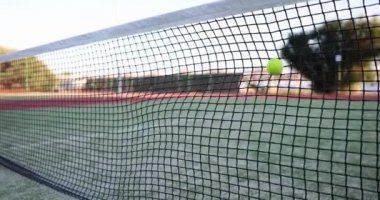 Sarı top tenis kortunda ağa vuruyor, yakın çekim, yavaş çekim. Büyük tenis oynamayı öğrenme konsepti, antrenman.