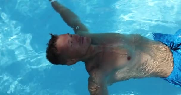 Hombre Piscina Acuesta Boca Arriba Con Los Brazos Extendidos Cerca — Vídeo de stock