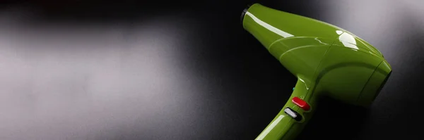 绿色专业吹风机在深色背景下的遮挡 头发护理概念 — 图库照片