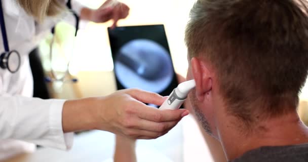 Ent Lekarz Badający Ucho Pacjenta Elektronicznym Otoskopem Pokazując Obraz Tablecie — Wideo stockowe