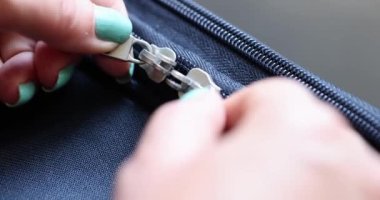 Kadın fermuarını açar ve mavi bavulu ya da spor çantasını bağlar. Poşetlerde kaliteli fermuarlar.