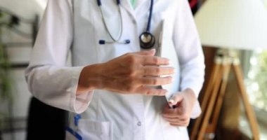 Kadın doktor ofiste el sıkışmayı teklif ediyor. Tıbbi hoş geldin ve sigorta
