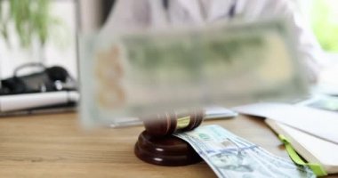 Doktor mahkeme tokmağı masasındaki klinikteki tıbbi belgelere not alıyor. İlaç yolsuzluğu, görevi kötüye kullanma ve yasaları çiğneme.