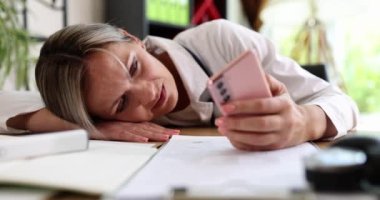 Üzgün kadın doktor telefona bakar ve aramasını bekler. Yalnızlık depresyonu ve doktorların aşırı çalışması