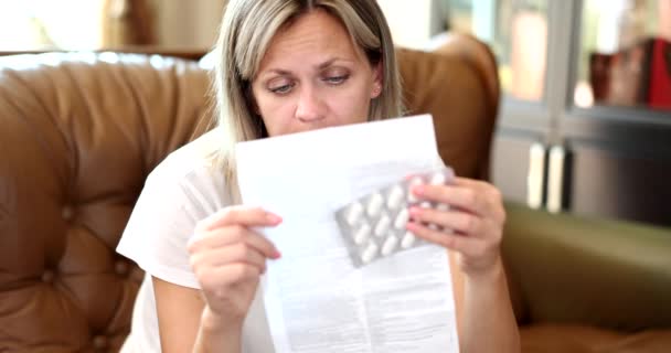 Mulher Lendo Instruções Para Droga Médica Enquanto Sentado Sofá Casa — Vídeo de Stock