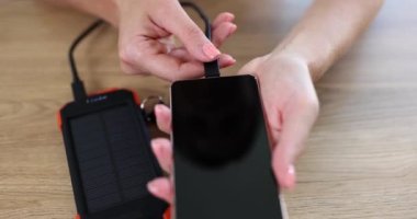 Kadın dış bataryadan akıllı telefonu şarj ediyor. Taşınabilir pil güç bankası kavramı