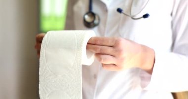 Doktor proktolog tuvalet kağıdı rulosu gösteriyor. Hemoroit tedavisi kabızlık ishal konsepti