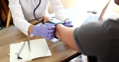 Doktor uzayan koluna kan basıncı monitörü takıyor. Arteriyel hipertansiyon ve basınç dalgalanmaları neden ve tedavi