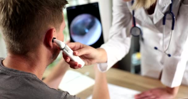 耳鼻喉科专家用数字耳镜对病人的耳朵进行医学检查 平板电脑屏幕上的耳朵测试结果 — 图库视频影像