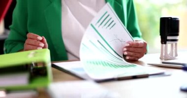 Menajer belgeleri grafiklerle inceliyor ve üzerine 4K yavaş çekim damgası yapıştırıyor. Belgelendirme kavramı sertifikası 