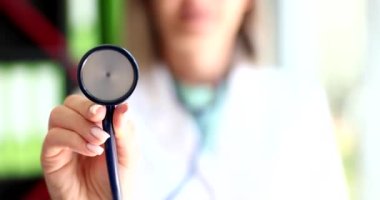 Kadın doktor steteskop tutuyor. Yakın çekim 4K film ağır çekim. Kardiyolog konsepti ile profesyonel danışma 